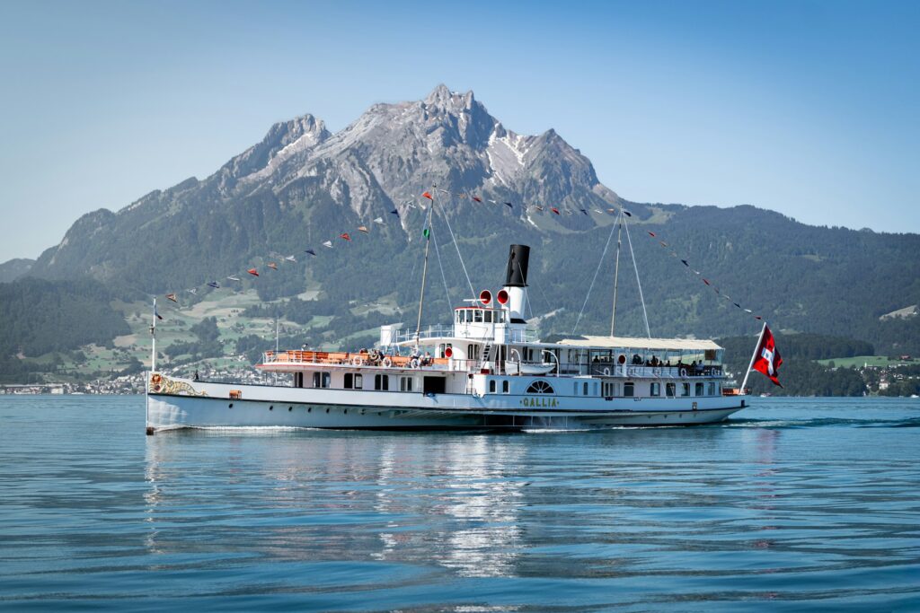 Barco a vapor histórico Gallia no lago de Lucerna, com uma montanha rochosa ao fundo